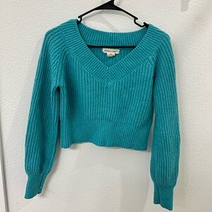 Teal cropped sweater with a v neckline